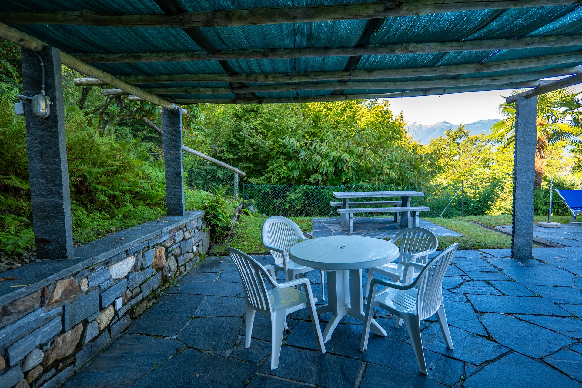 Überdachte Pergola mit Gartenmöbeln bei der Residenza Viramonte